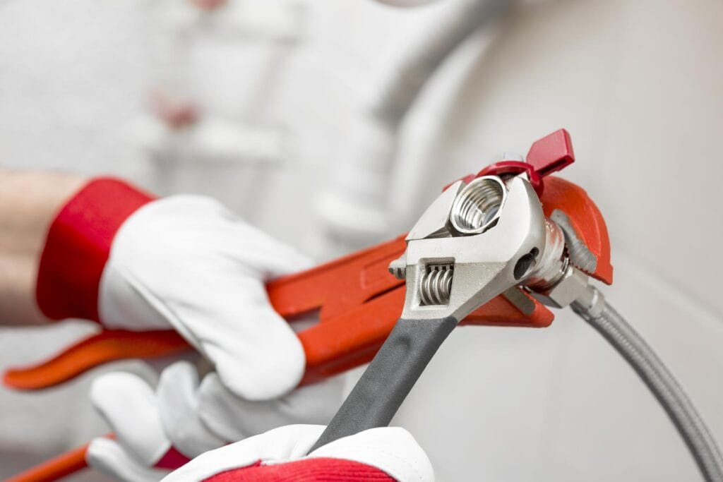 Plumber holding pipe wrenches for an emergency repair in Silver Spring