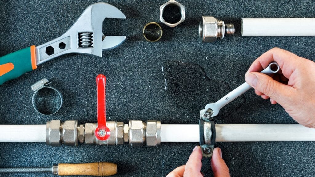 Plumber repairing a pipe valve with an adjustable wrench in Silver Spring