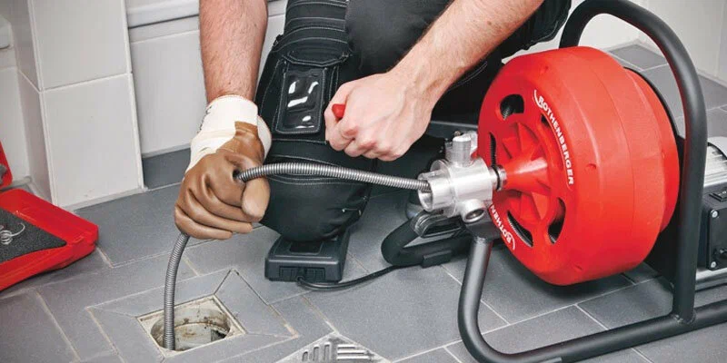 Plumber using a drain-cleaning machine in Silver Spring